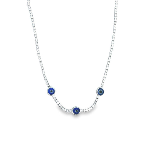 A sparkling silver tennis necklace features three blue and white evil eye charms hanging delicately against a plain white background.