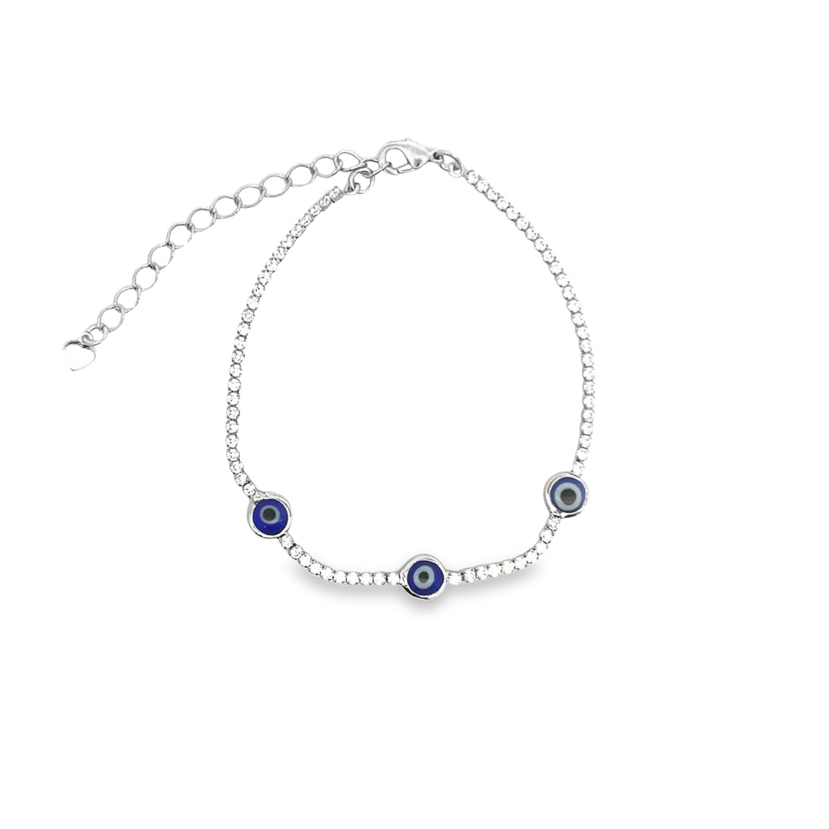 A delicate silver tennis bracelet adorned with sparkling cubic zirconia stones and three traditional blue evil eye charms rests against a plain white background.