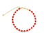 A gold-accented beaded bracelet features alternating red and metallic gold beads arranged in a circle against a clean white background.