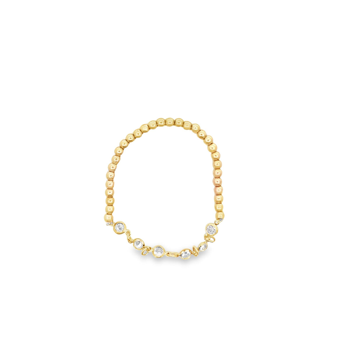 A delicate gold beaded ring features a string of sparkling bezel-set diamonds along the bottom.