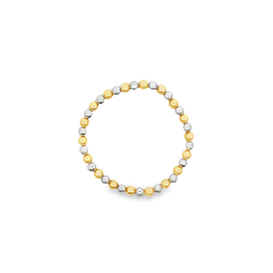 A delicate beaded ring showcases alternating gold and silver spheres arranged in a continuous circle against a clean white background.