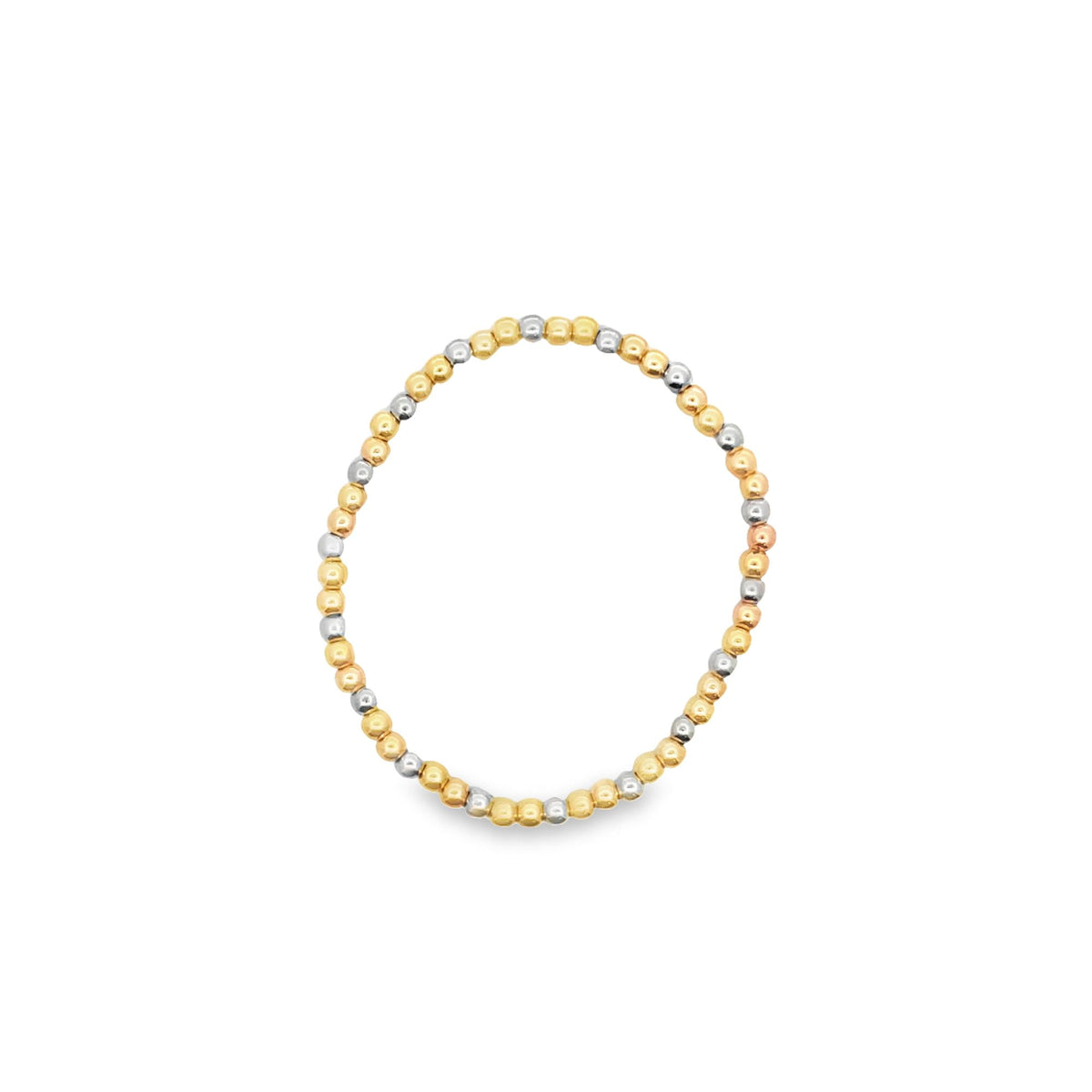 A stretchy gold and silver bead ring rests isolated on a white background.