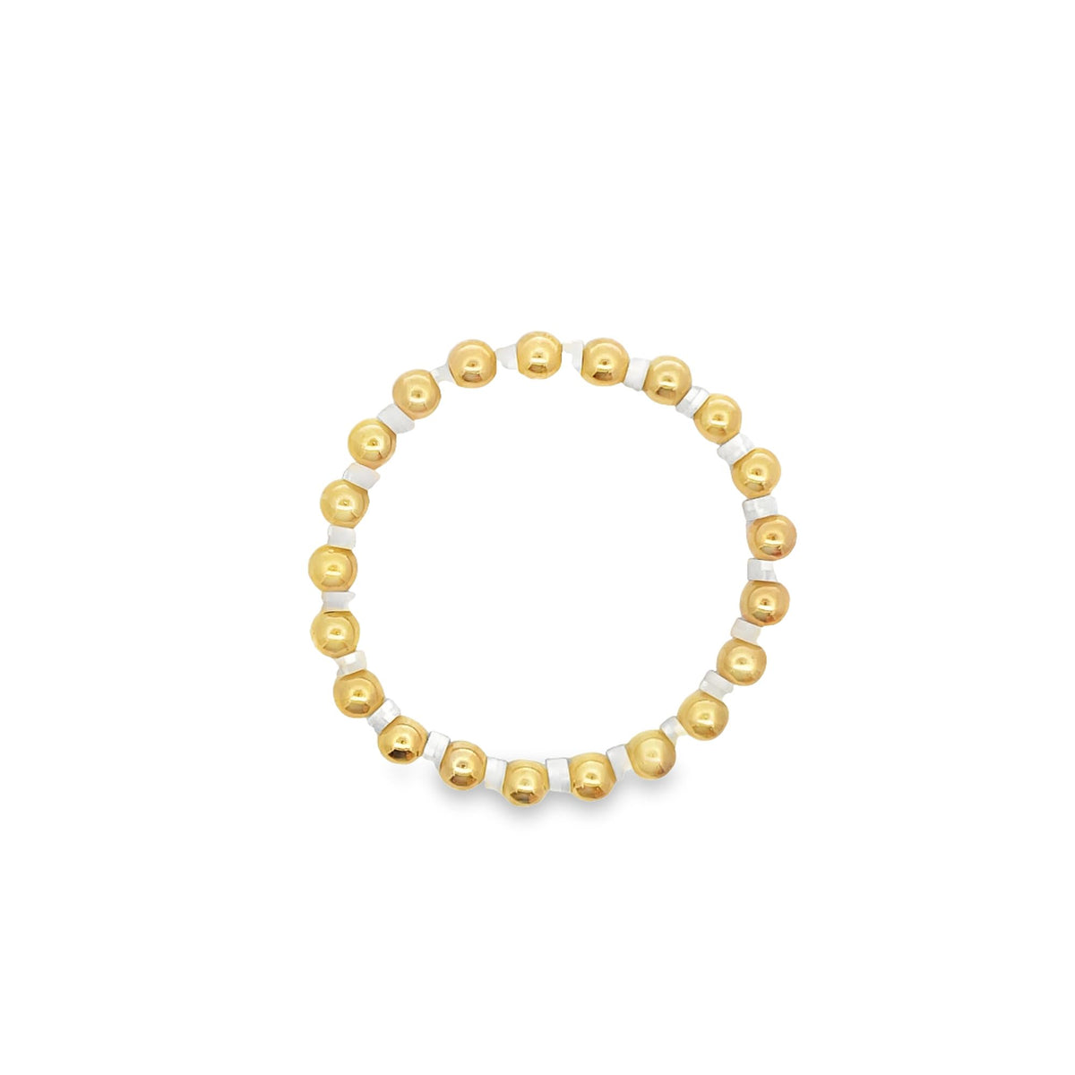 A gold bead and white spacer bracelet rests on a clean white background.