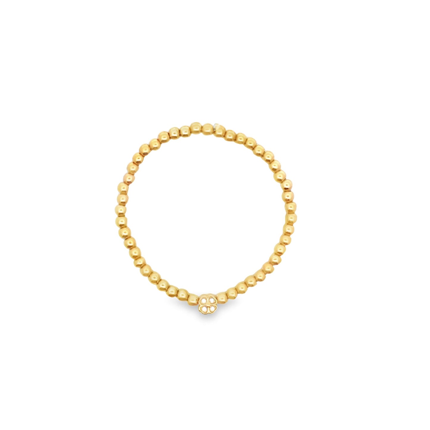 A delicate gold bead stretch ring features a small clover-shaped charm on a plain white background.