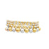 A stack of shiny gold and silver beaded stretch bracelets displays alternating metallic spheres against a clean white background.