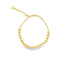 A gold bead bracelet with an adjustable chain and a tiny heart charm rests against a white background.