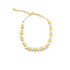 A delicate two-tone gold and silver beaded bracelet features alternating metallic spherical beads and an adjustable chain clasp against a white background.