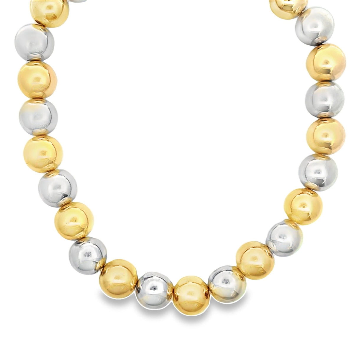 A two-tone beaded necklace features alternating polished yellow gold and silver spheres arranged in a curved pattern.