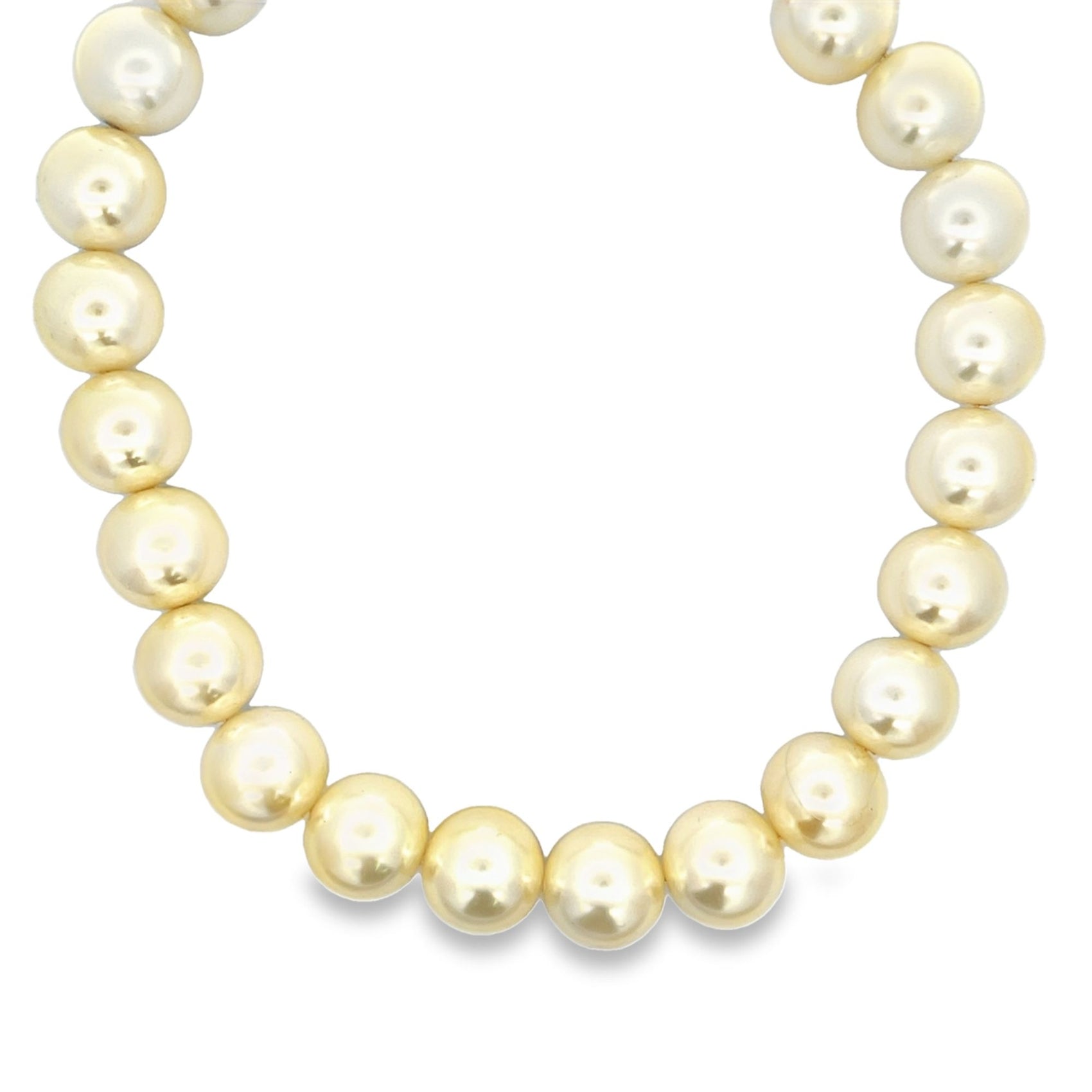 A luxurious strand of glowing South Sea pearls curves gracefully against a plain white background.