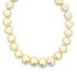 A luxurious strand of glowing South Sea pearls curves gracefully against a plain white background.