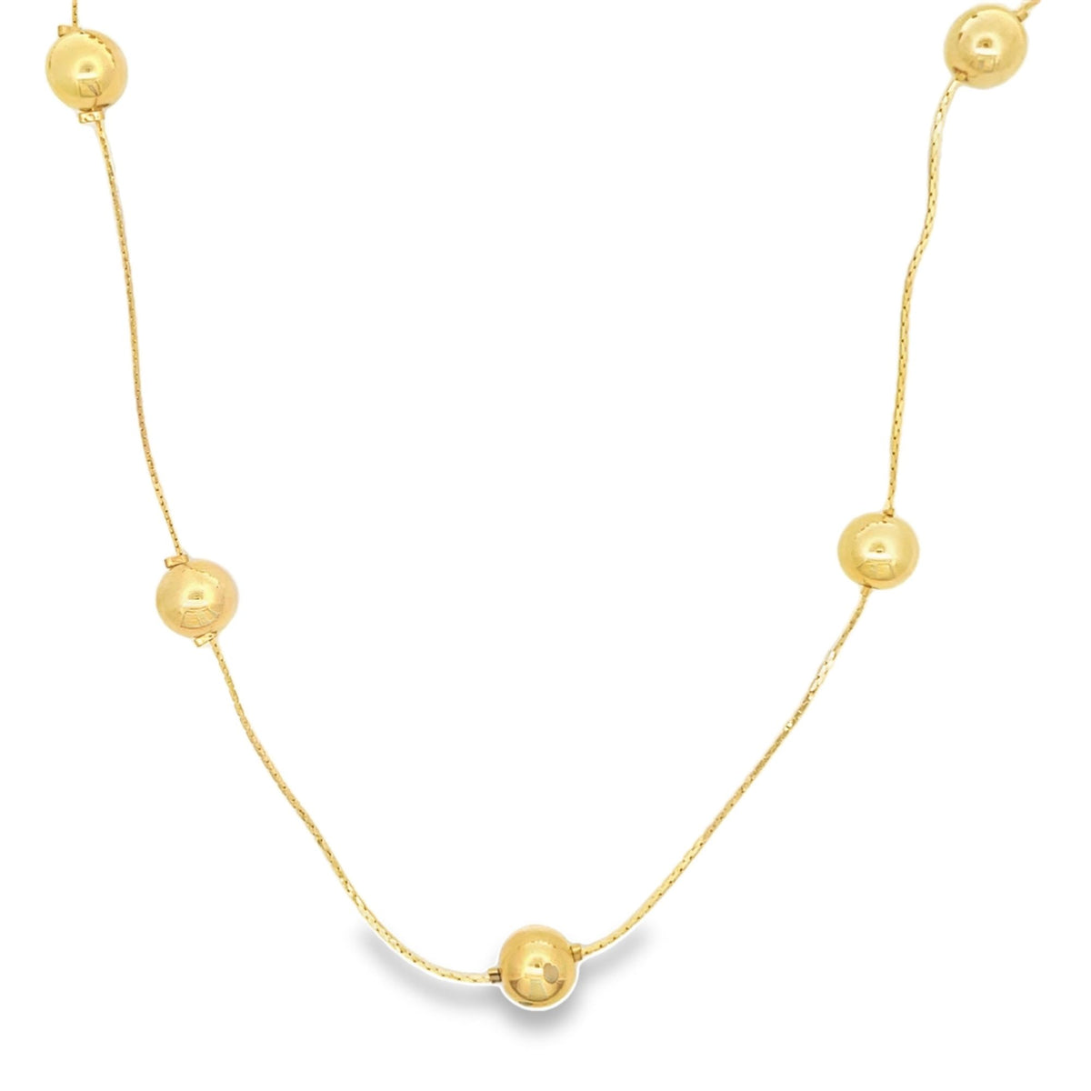 A delicate gold chain necklace drapes elegantly, featuring evenly spaced polished round gold beads against a clean white background.