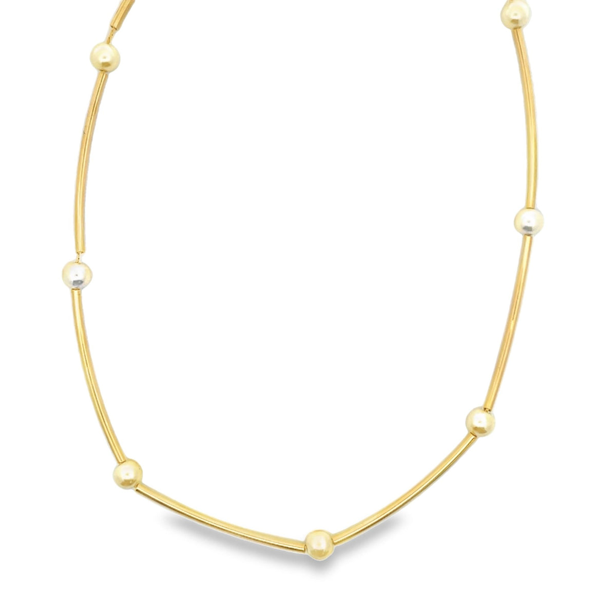 A minimalist gold chain necklace features alternating yellow gold bars and small bead accents against a clean white background.