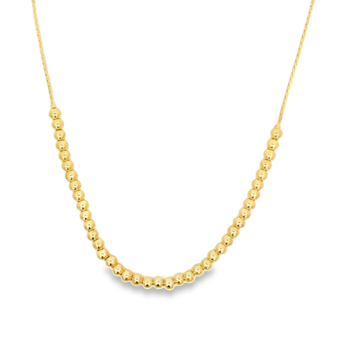 A delicate gold beaded necklace hangs against a plain white background, featuring a curved arrangement of polished spherical beads along a fine chain.