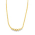 A delicate gold beaded necklace features a graduated design with larger spheres resting at the center.