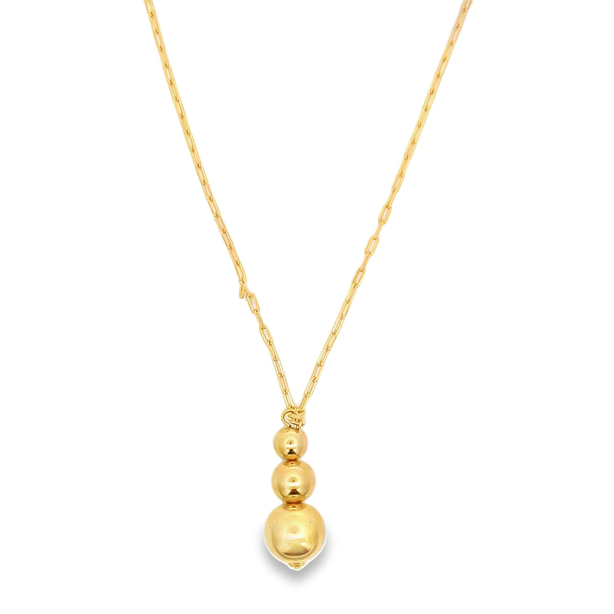 A delicate gold chain necklace features three graduated shiny spheres suspended as a pendant.