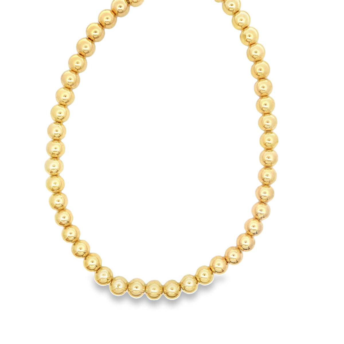 A delicate gold ball bead necklace forms a smooth, circular loop against a clean white background.