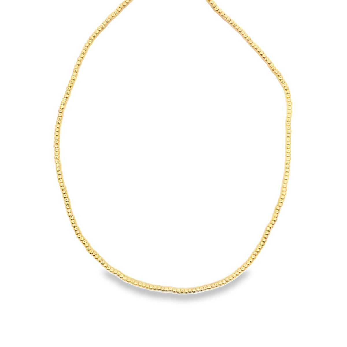 A delicate gold beaded necklace forms an oval loop against a clean white background.