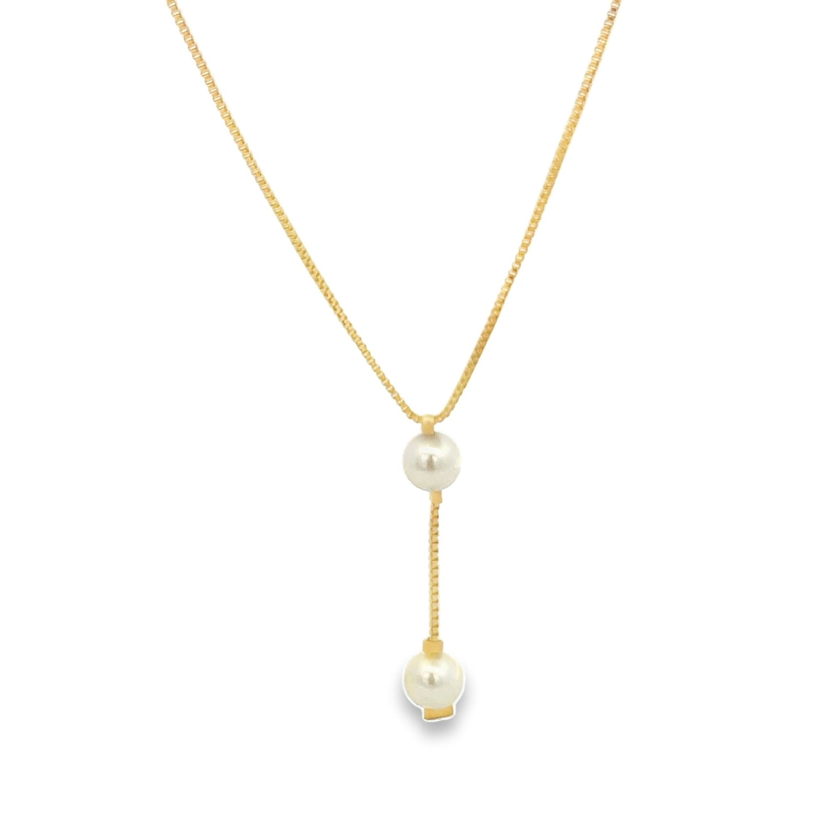 A delicate gold lariat necklace features two dangling pearls against a clean white background.