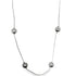A delicate silver necklace features polished spherical metal beads spaced along its thin chain against a plain white background.