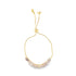 A delicate gold bolo bracelet features a curved row of marquise-cut pink stones and an adjustable slider clasp.
