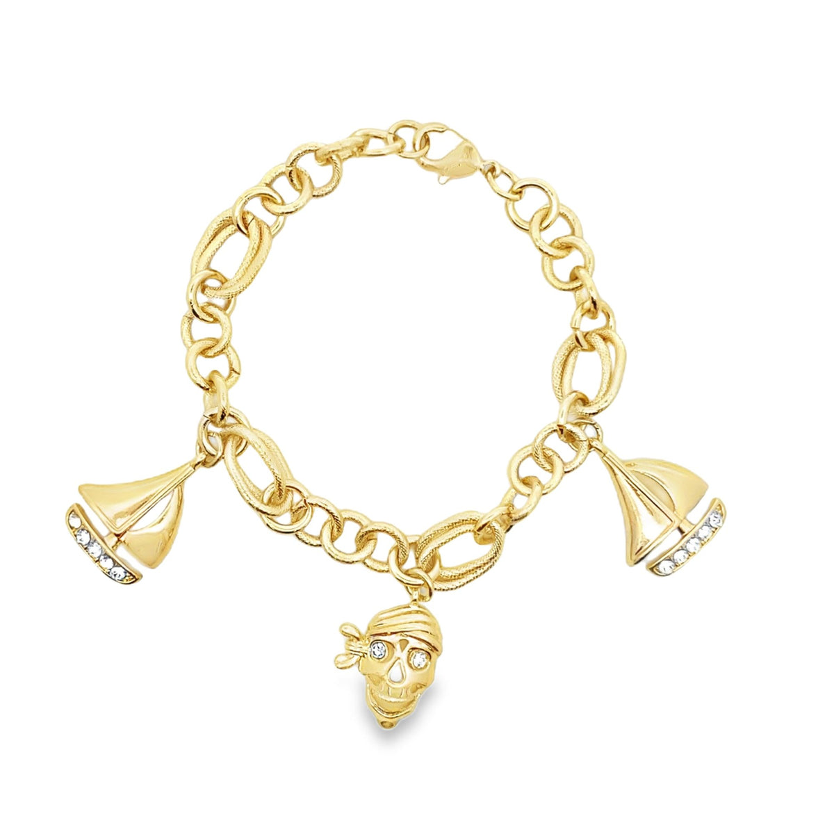 A gold charm bracelet features dangling sailboat charms set with sparkling crystals and a central pirate skull charm against a white background.