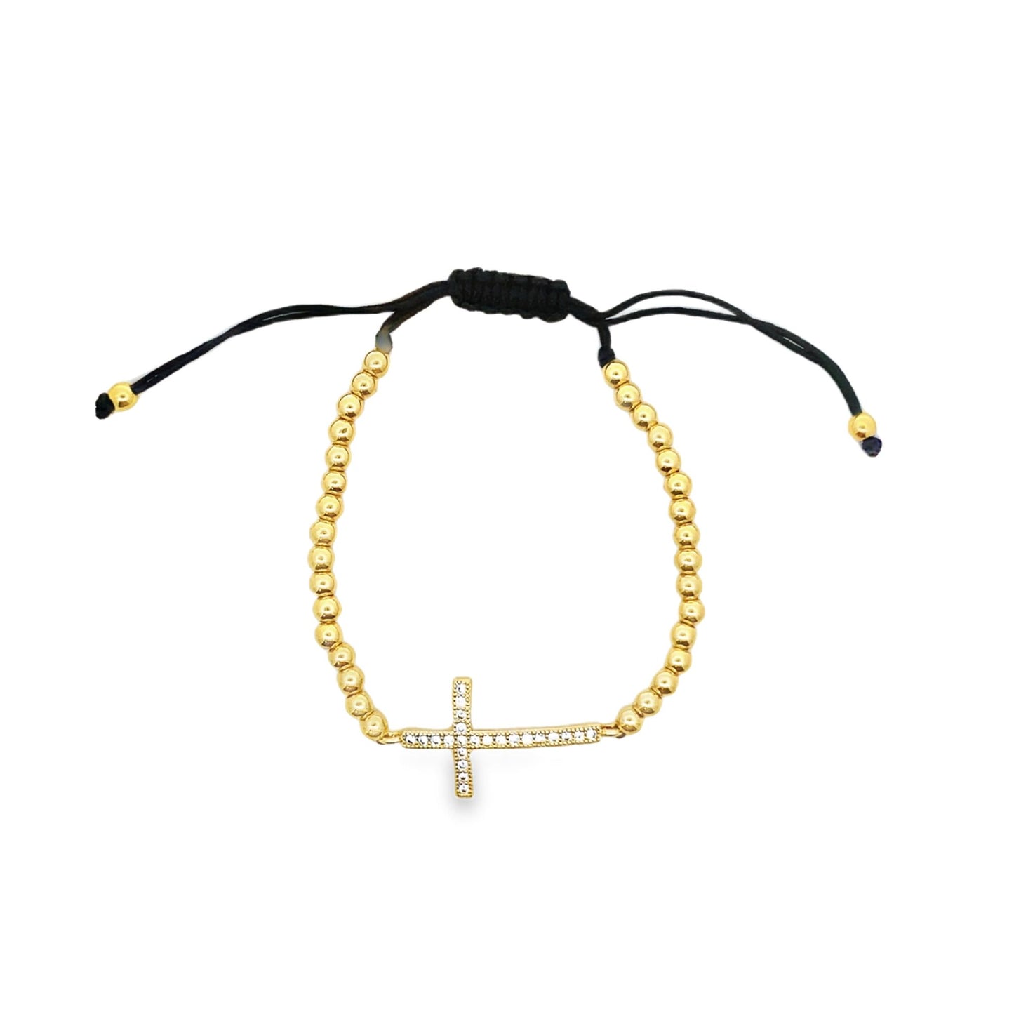 A gold bead adjustable bracelet features a sparkling crystal-encrusted cross charm centered on a white background.