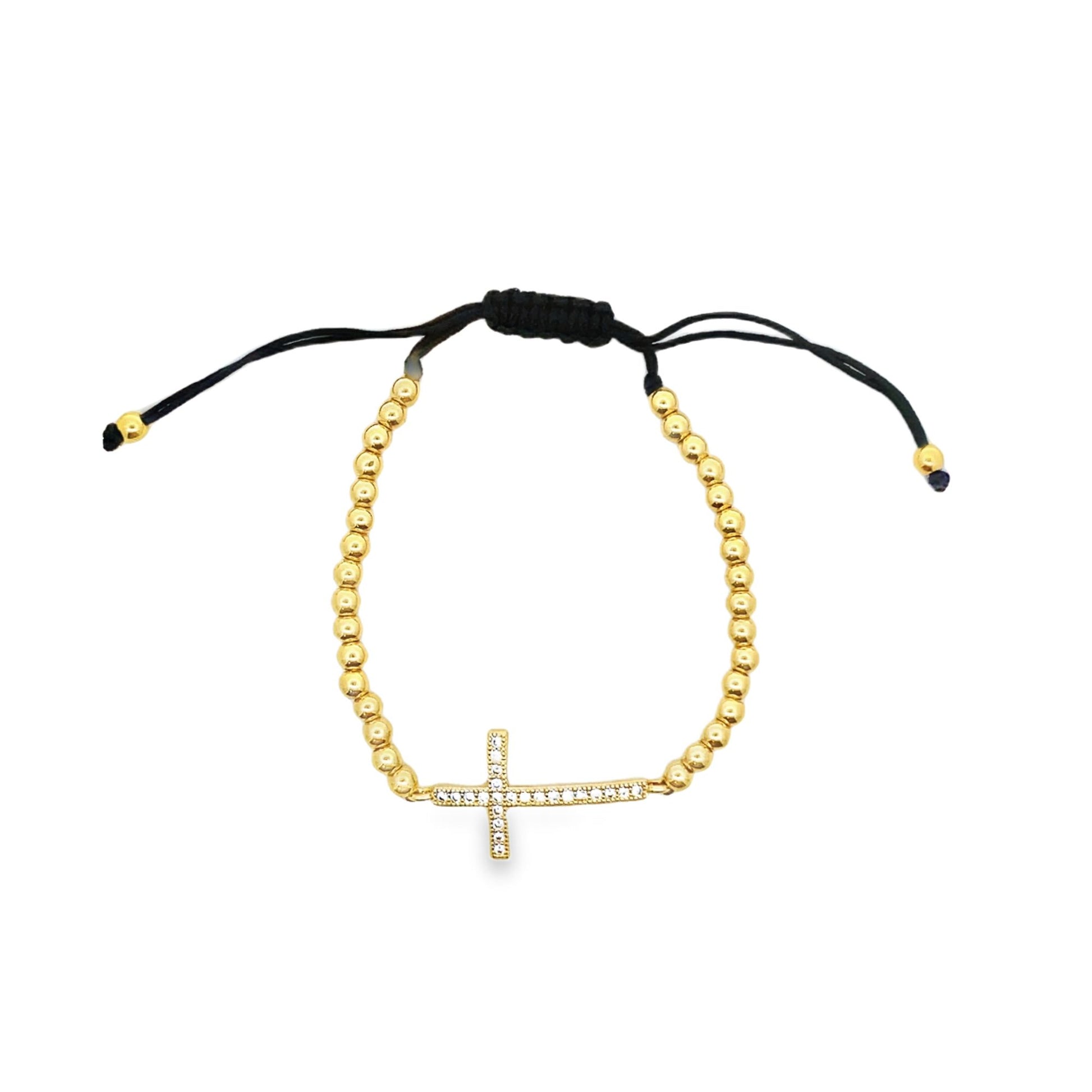 A gold bead adjustable bracelet features a sparkling crystal-encrusted cross charm centered on a white background.