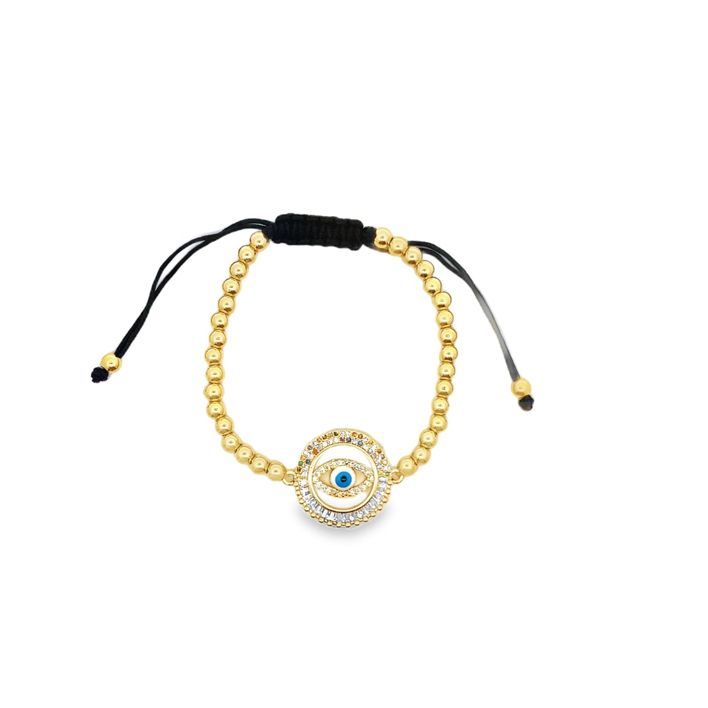 A delicate gold bead bracelet features a sparkling evil eye charm and adjustable black cord ties against a clean white background.