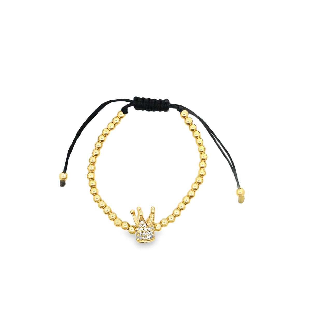 A delicate gold beaded crown charm bracelet rests on a white background, featuring an adjustable black cord closure.