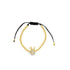 A delicate gold beaded crown charm bracelet rests on a white background, featuring an adjustable black cord closure.