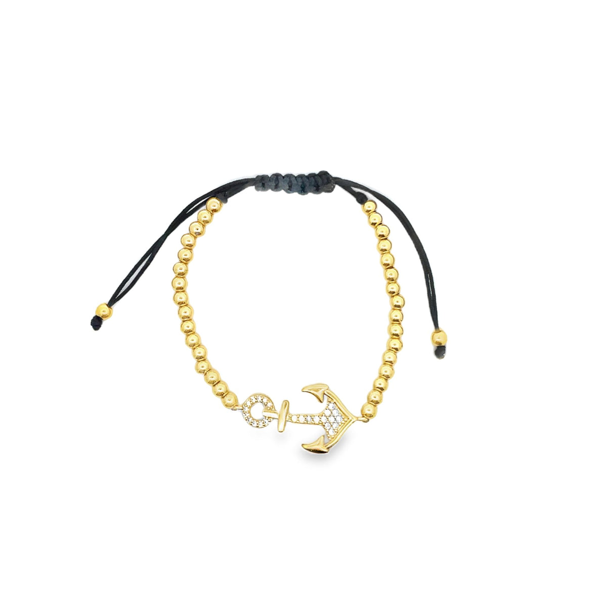 A gold anchor charm bracelet with glittering pavé diamonds features shiny metal beads along a black adjustable cord.