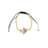 A gold-beaded Hamsa hand charm bracelet with multicolored pavé stones rests on a white background.
