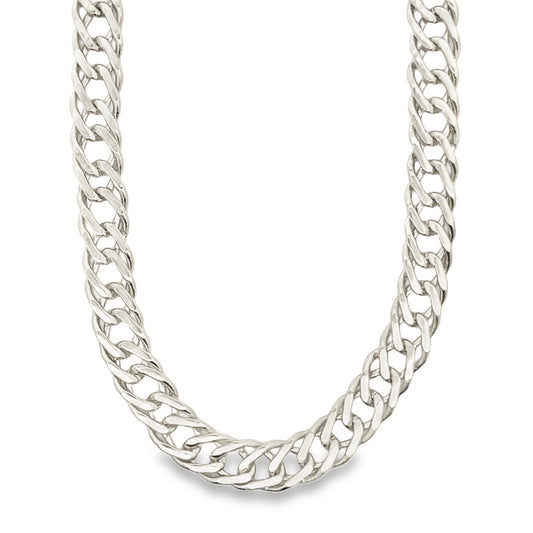 A thick, polished silver curb chain necklace rests gracefully against a clean white background.