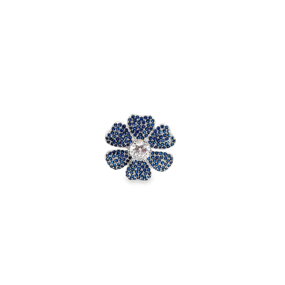 A silver flower-shaped earring sparkles with pavé-set blue sapphires and a central round diamond.
