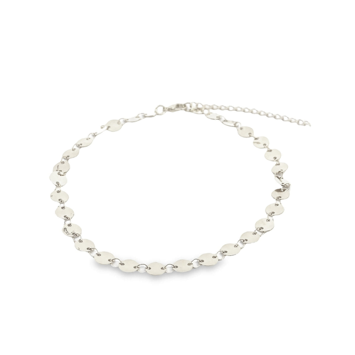 A delicate silver coin choker necklace rests on a plain white surface.