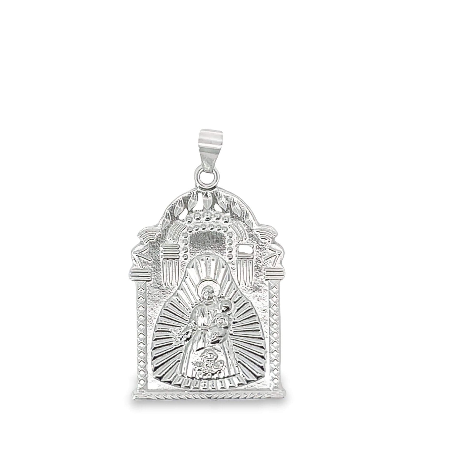 A polished sterling silver religious pendant displays an intricate, arched frame featuring an embossed image of the Virgin Mary and child surrounded by radiating sunburst details.