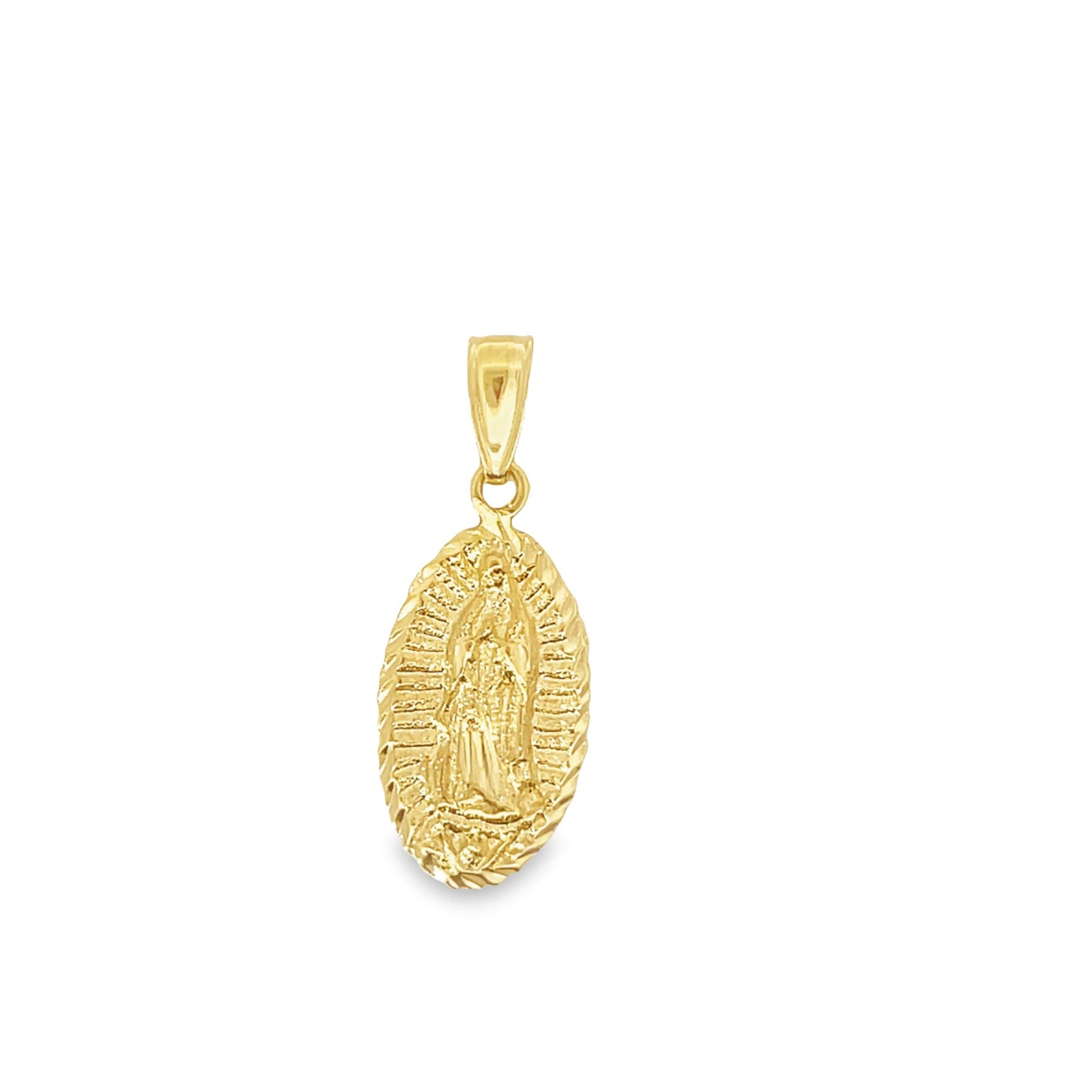 An ornate gold pendant displays the detailed figure of Our Lady of Guadalupe inside an oval frame against a white background.