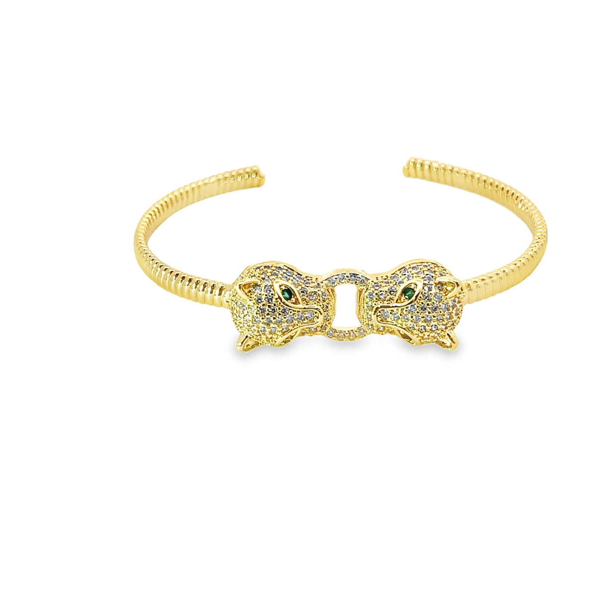 A gold cuff bracelet features two pave-set diamond panther heads facing each other with striking green gemstone eyes.
