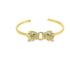 A gold cuff bracelet features two pave-set diamond panther heads facing each other with striking green gemstone eyes.