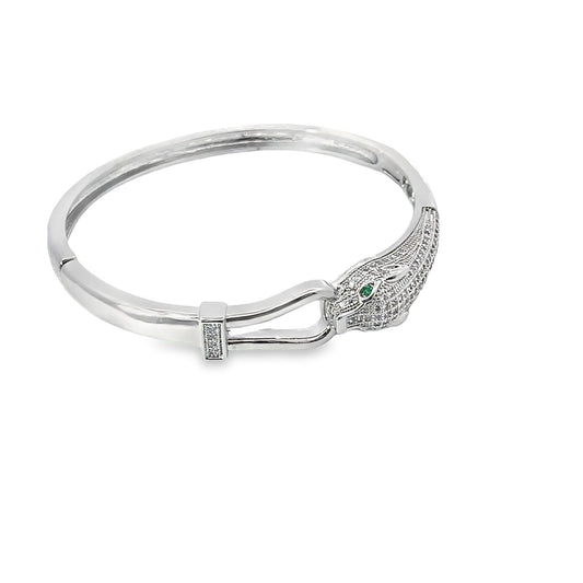 A silver panther bangle bracelet features sparkling pave-set cubic zirconia crystals and striking green emerald eyes.