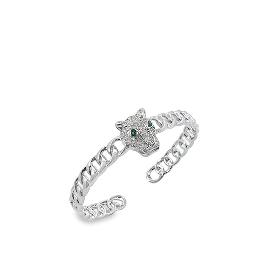 A silver cuban link cuff ring showcases a sparkling panther head centerpiece with vibrant green gemstone eyes.