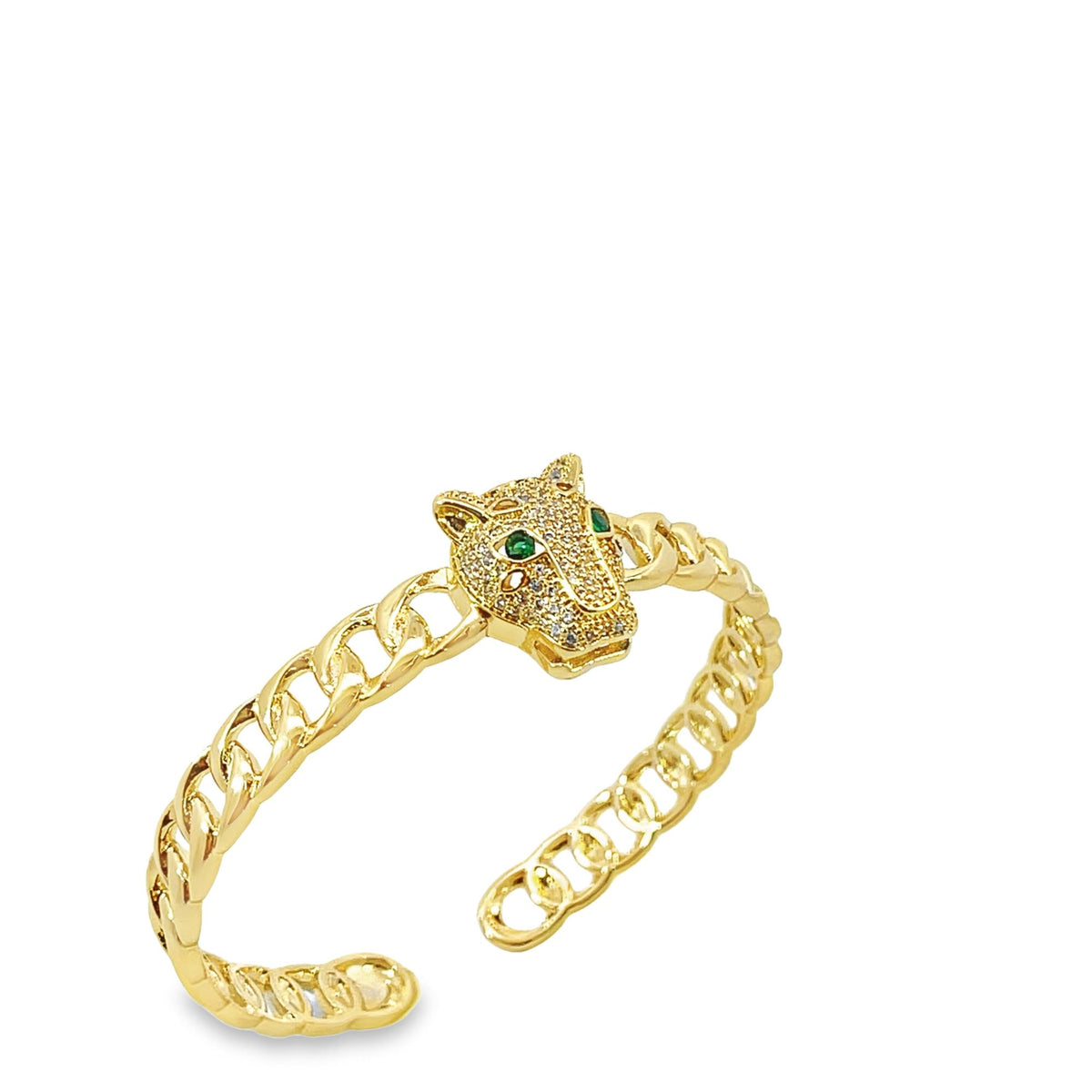 A gold panther cuff bracelet features a pavé-set diamond head with striking green gemstone eyes and a curb chain band against a clean white background.