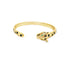 A gold panther cuff bracelet features intricate black enamel spots and striking green gemstone eyes against a clean white background.