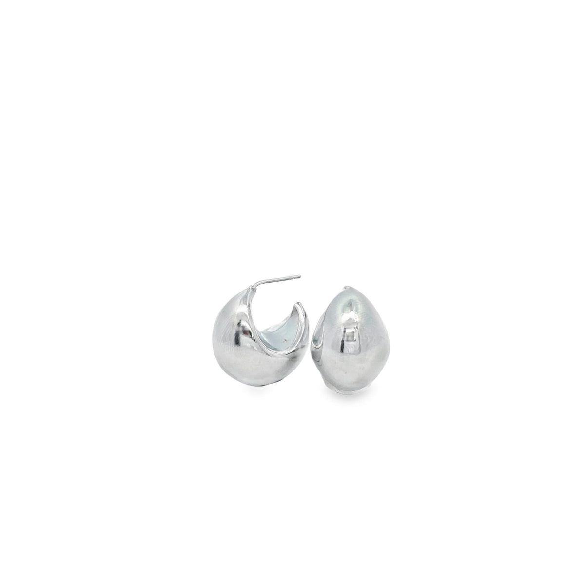 A pair of thick, polished silver hoop earrings rests against a clean white background.