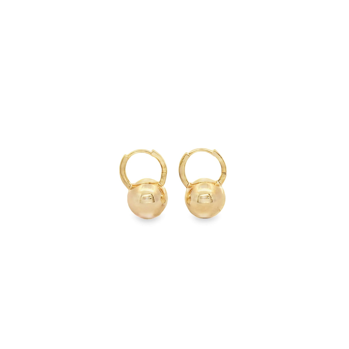A pair of shiny gold ball drop huggie hoop earrings rests against a clean white background.