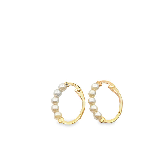 A pair of gold hoop earrings embellished with small white pearls sits against a plain white background.