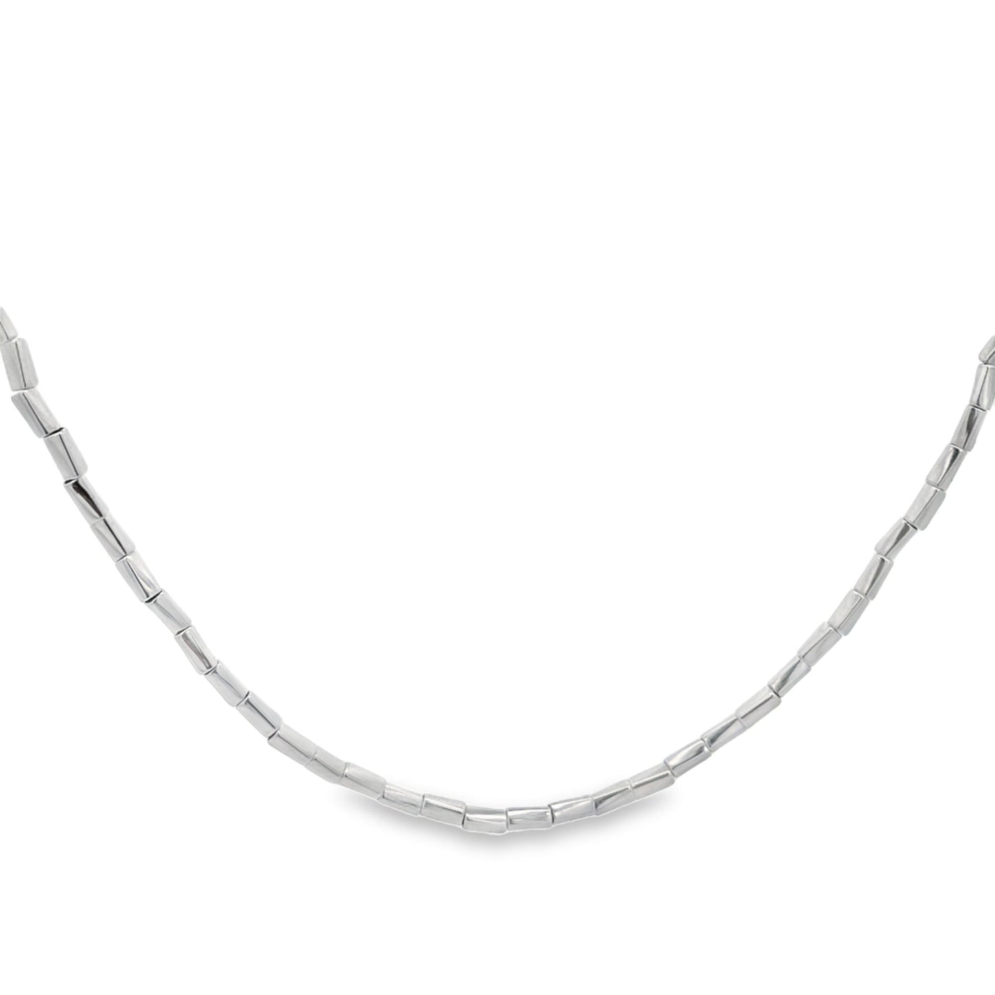 A polished sterling silver beaded necklace curves gracefully against a clean white background.