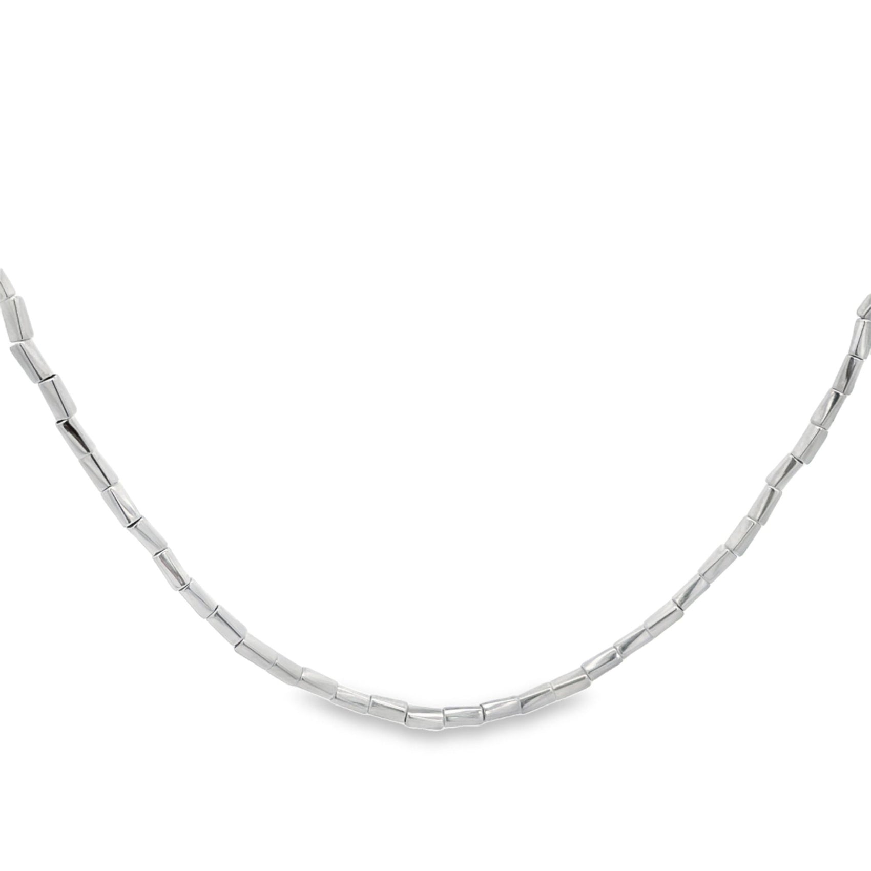 A polished sterling silver beaded necklace curves gracefully against a clean white background.
