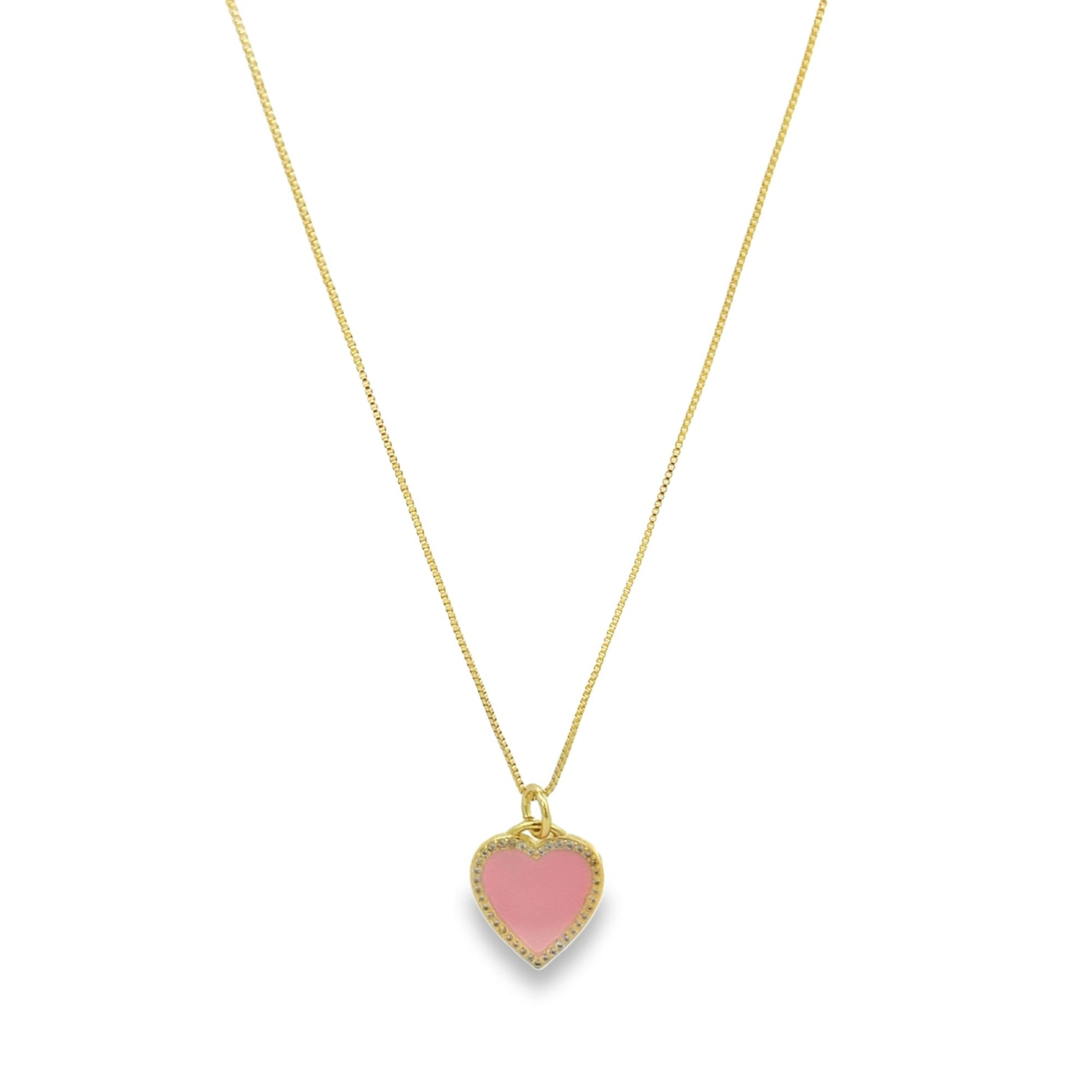A delicate gold chain necklace dangles, featuring a charming pink enamel heart pendant edged with sparkling pave crystals.