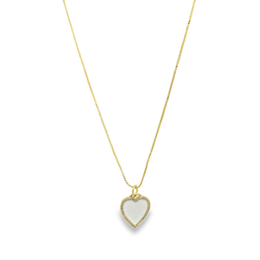 A delicate gold chain necklace displays a sparkling heart-shaped pendant with a white enamel inlay.
